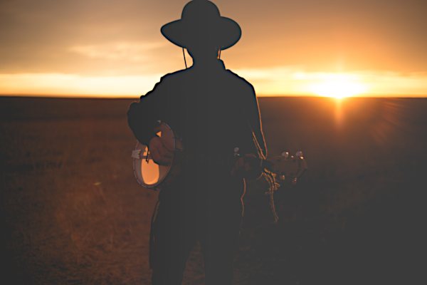 Cowboy spielt Musikinstrument Abendstimmung